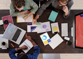Overhead view of a diverse team collaborating on a project in a modern office setting.